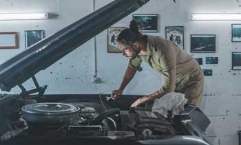 Man repairing car in garage - Feature Image
