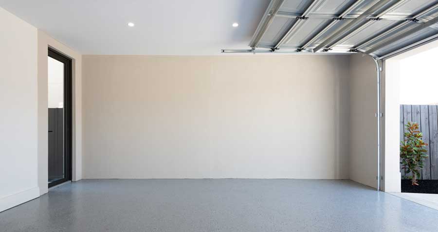 Empty garage with door open highlighting clean garage wall panels with fresh paint