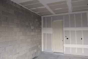 Garage under construction with concrete and drywall - Feature Image