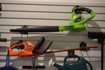 Leaf blower and hedge trimmer stored on garage wall - Feature Image
