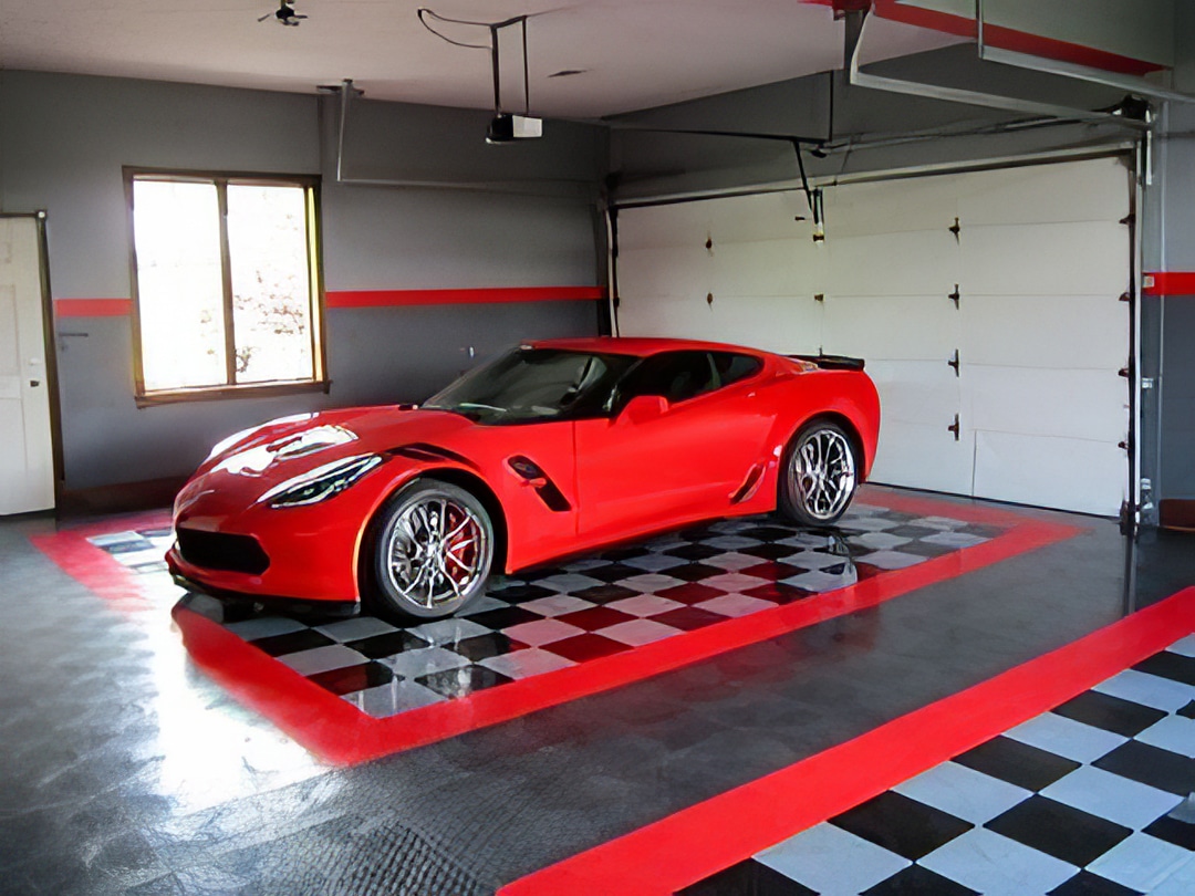 Corvette parked in garage with gray walls and a red stripe
