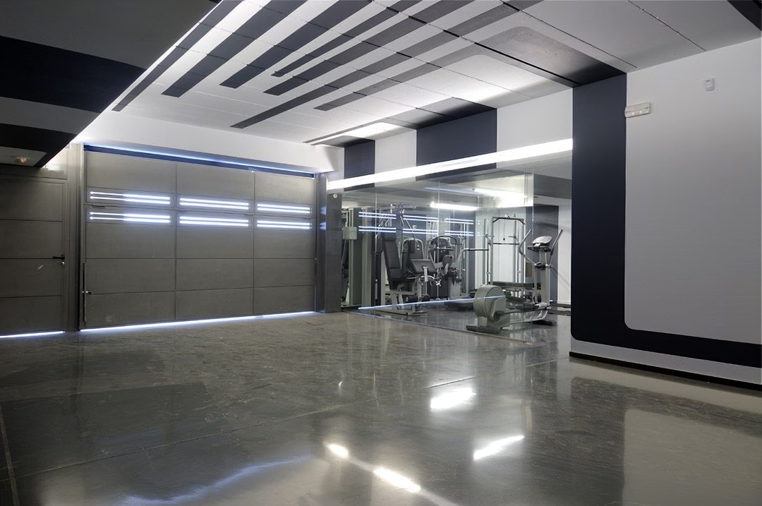 Dark gray walls with black accents in this garage gym