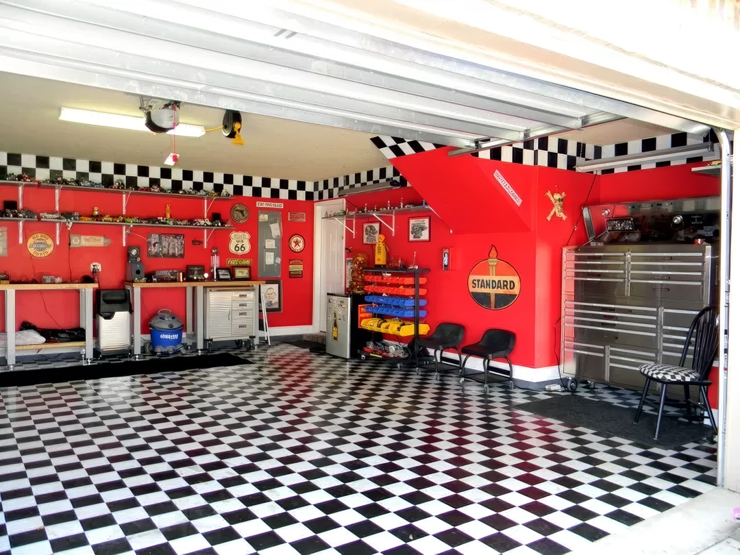 garage with red walls, checkerboard flooring and vintage signs