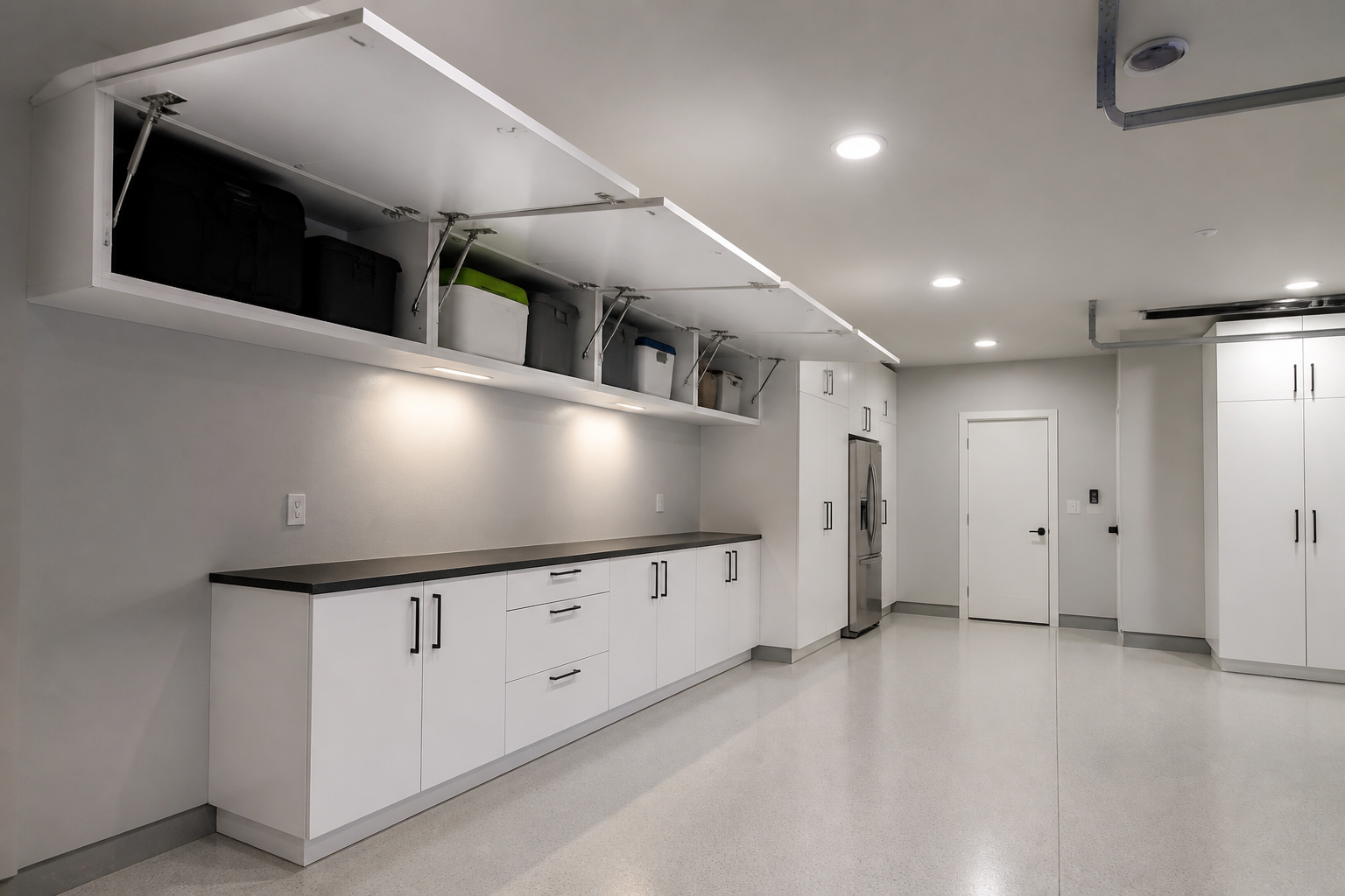 White overhead garage cabinets mounted flush to ceiling with drop-down doors