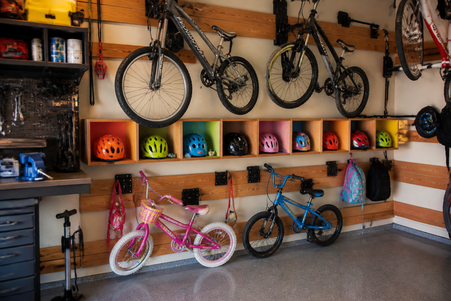 Kid-friendly bike storage zone with lower racks and colorful helmet cubbies at child height