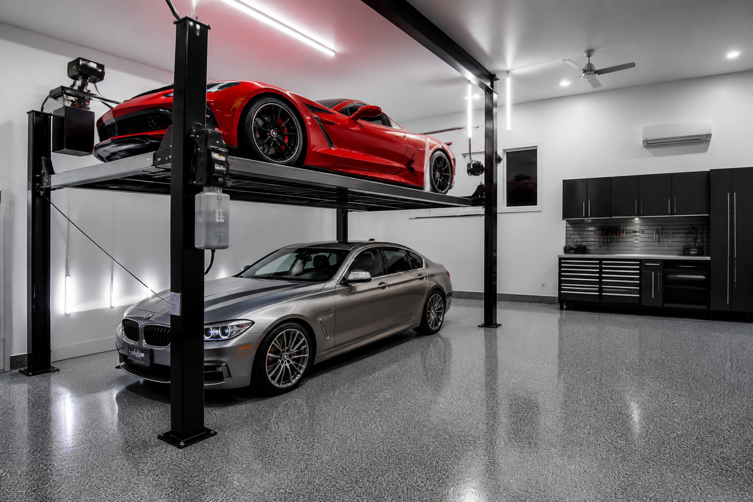 Four-post double-stacker car lift with red sports car elevated above silver sedan in modern garage