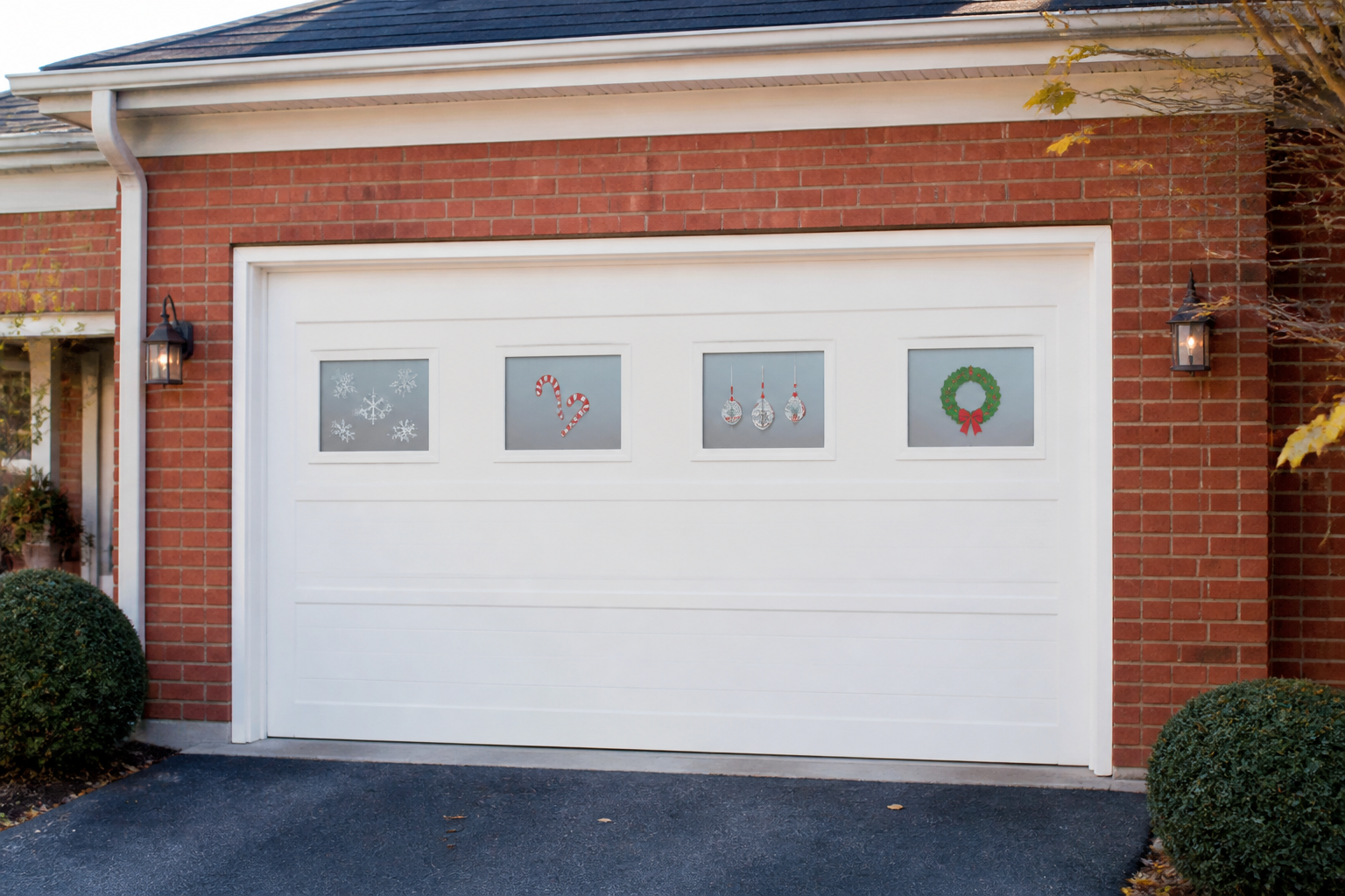 Row of garage windows decorated with festive window clings showing snowflakes and candy canes