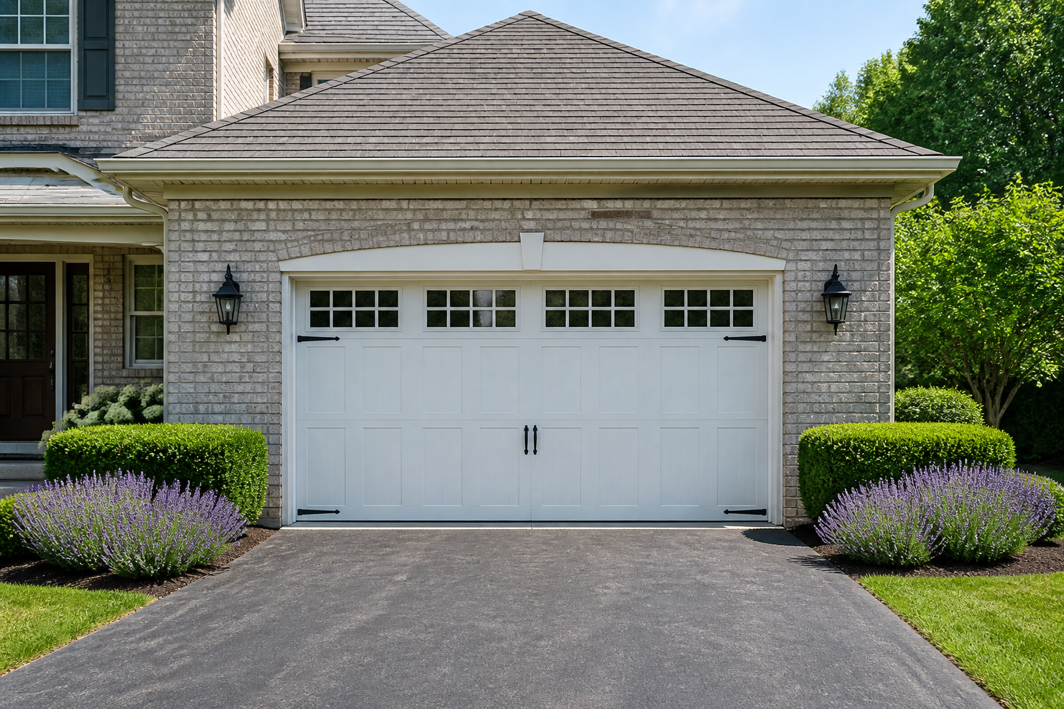 Symmetrical boxwood hedges and lavender plantings along garage foundation with brick facade