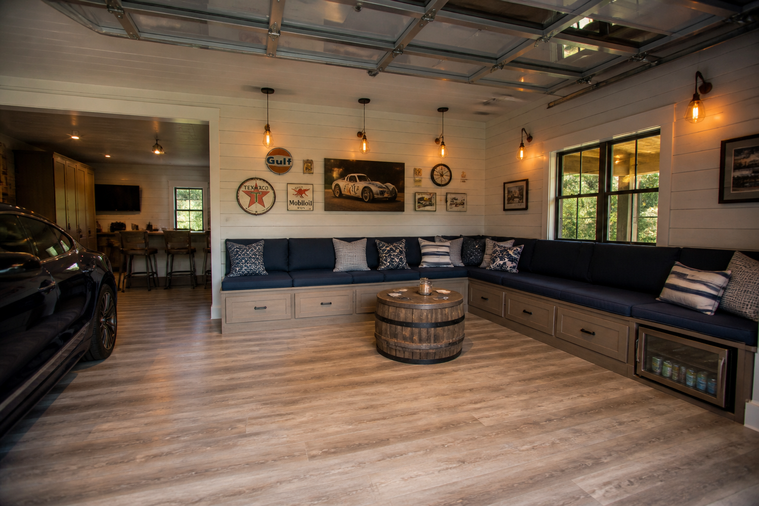 Built-in bench seating garage lounge with upholstered cushions and whiskey barrel coffee table