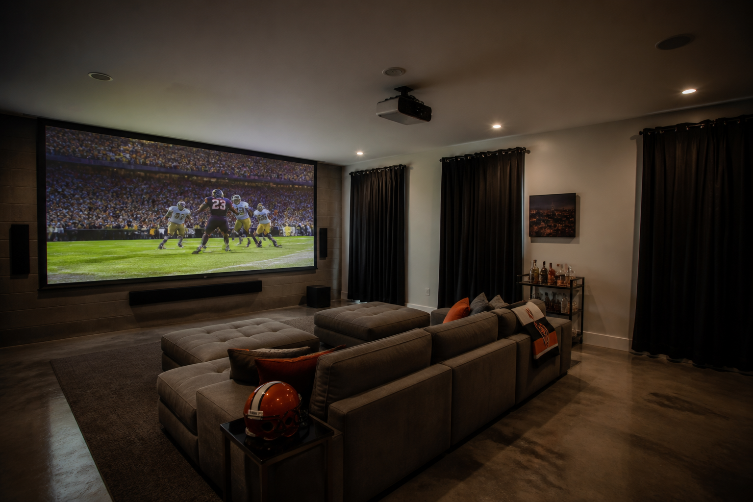 Projector-based garage sports viewing area with full wall screen and low-profile sectional seating