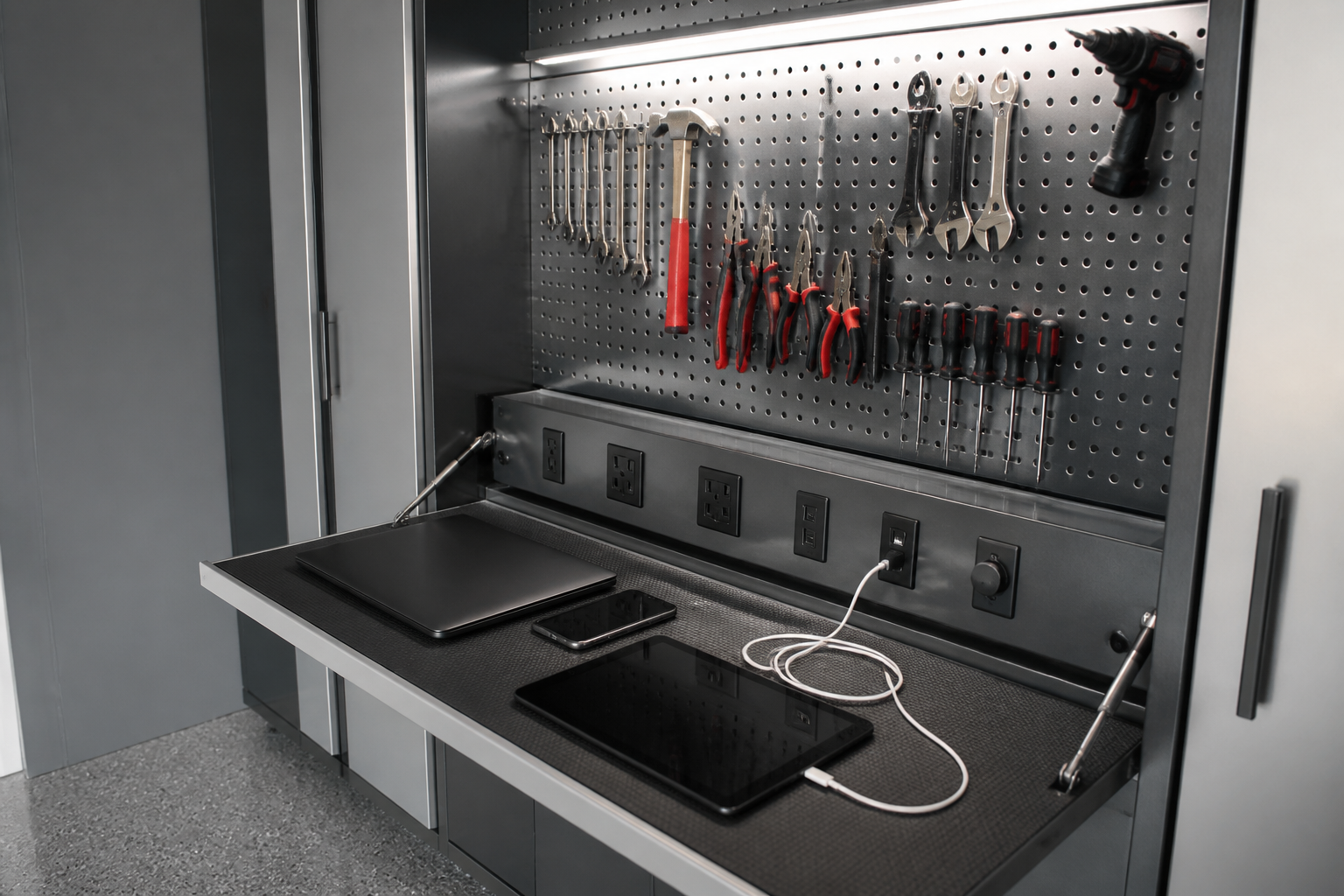 Flip-down pegboard panel revealing hidden charging outlets in garage
