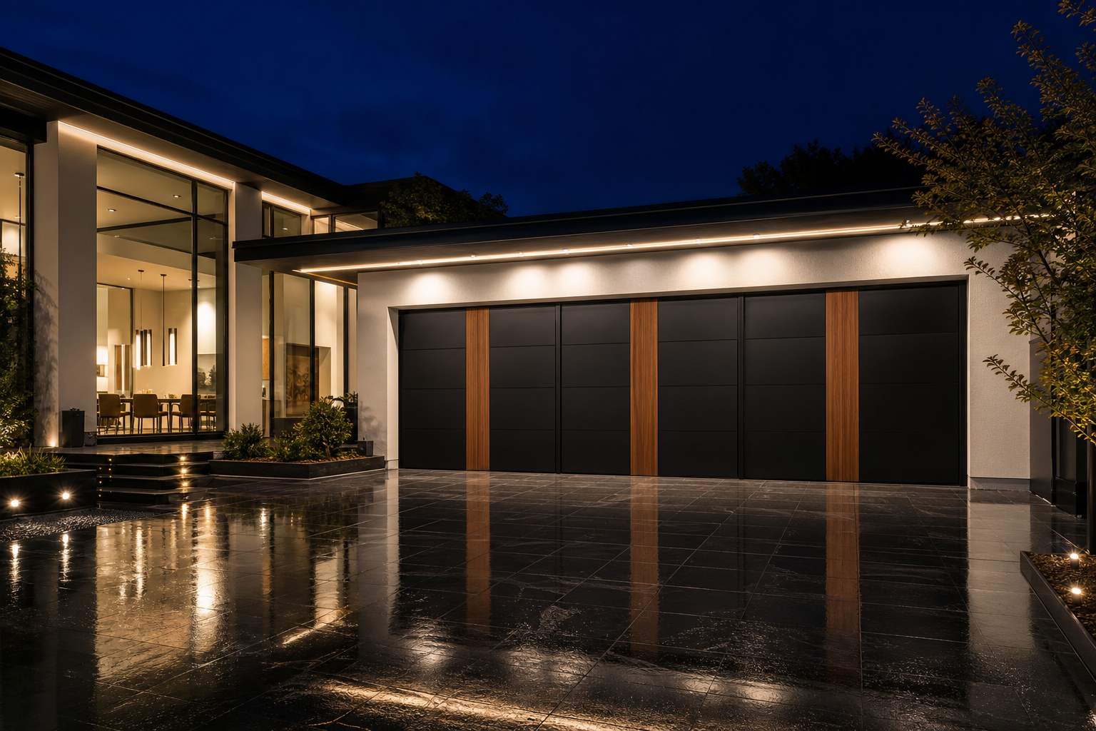 Black aluminum garage doors with vertical dark walnut wood inlay strips on a white luxury home at night