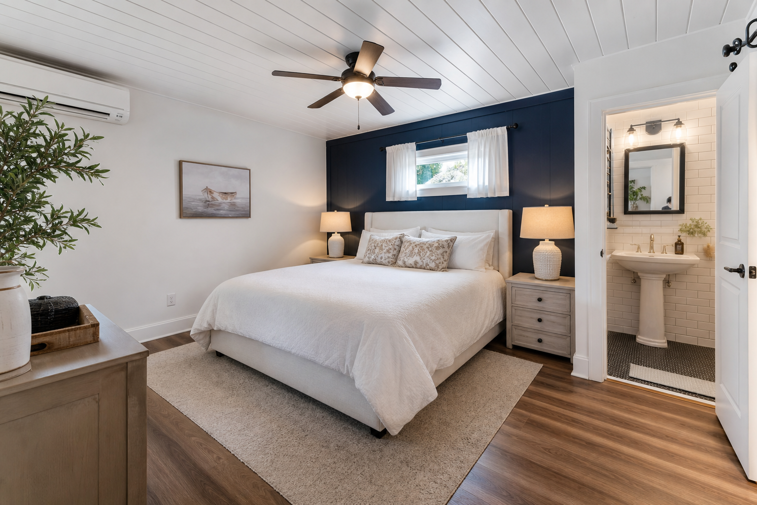 Guest bedroom suite in converted detached garage with navy accent wall en suite bathroom and ceiling fan