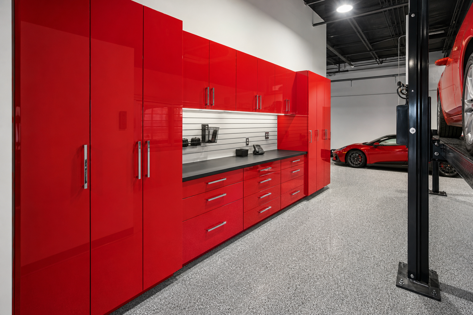 High-gloss red garage cabinets with chrome handles in a sports car garage
