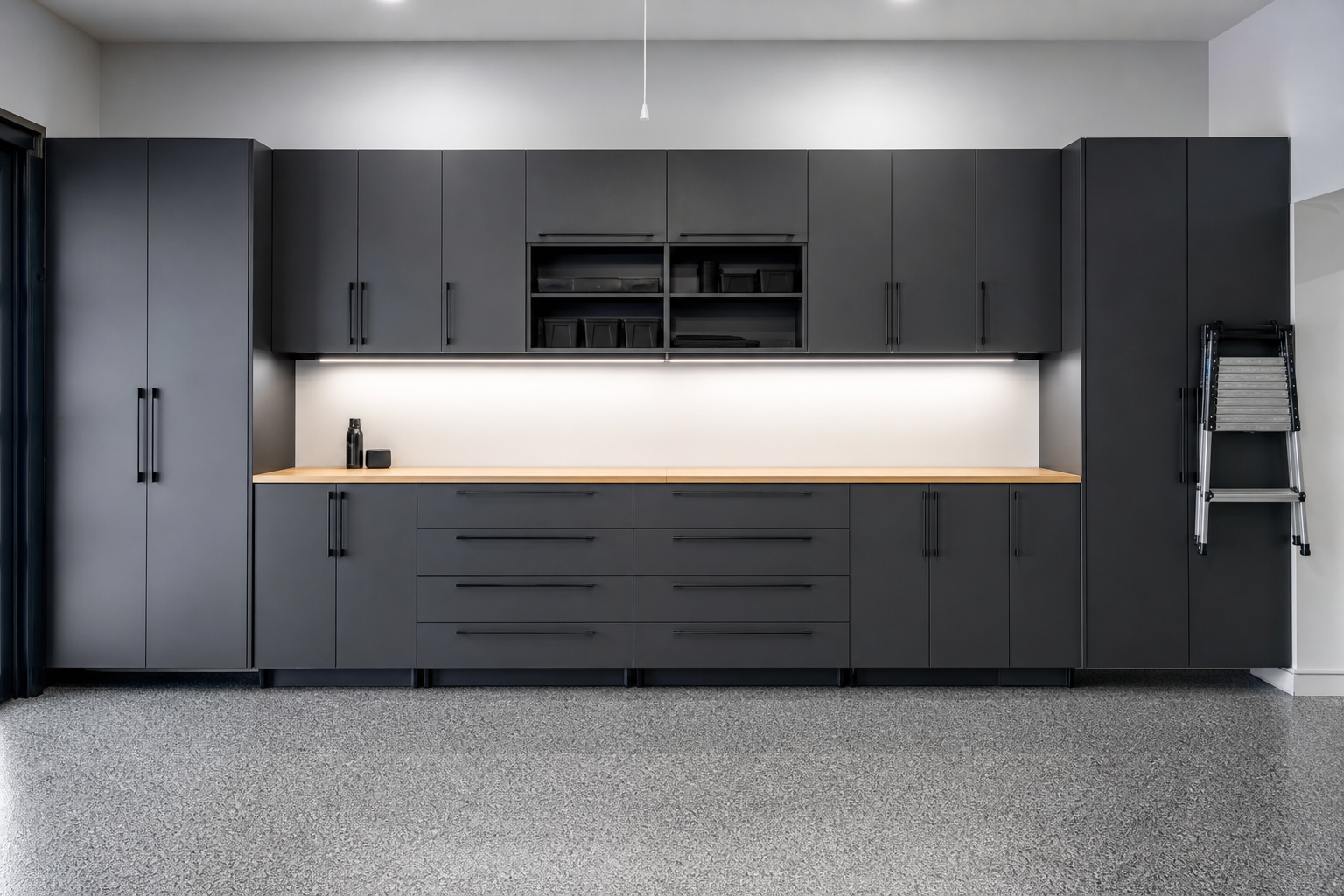 Dark charcoal gray modular garage cabinets covering full wall with mixed storage types
