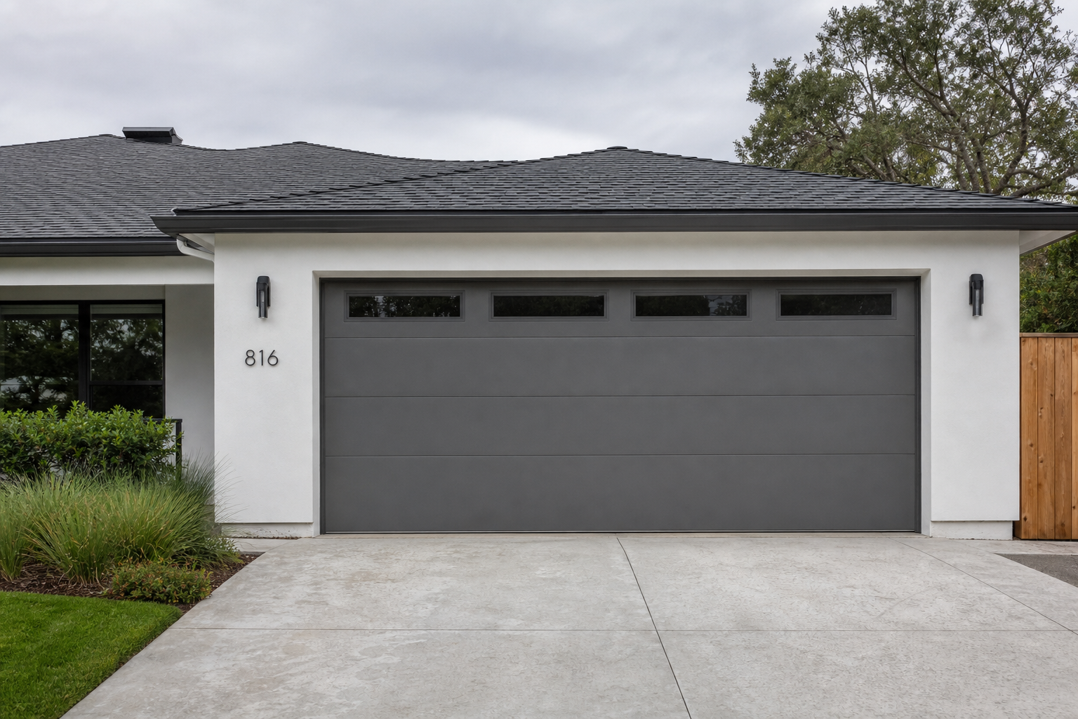 Light charcoal gray smooth flush-panel garage door on a modern ranch-style home