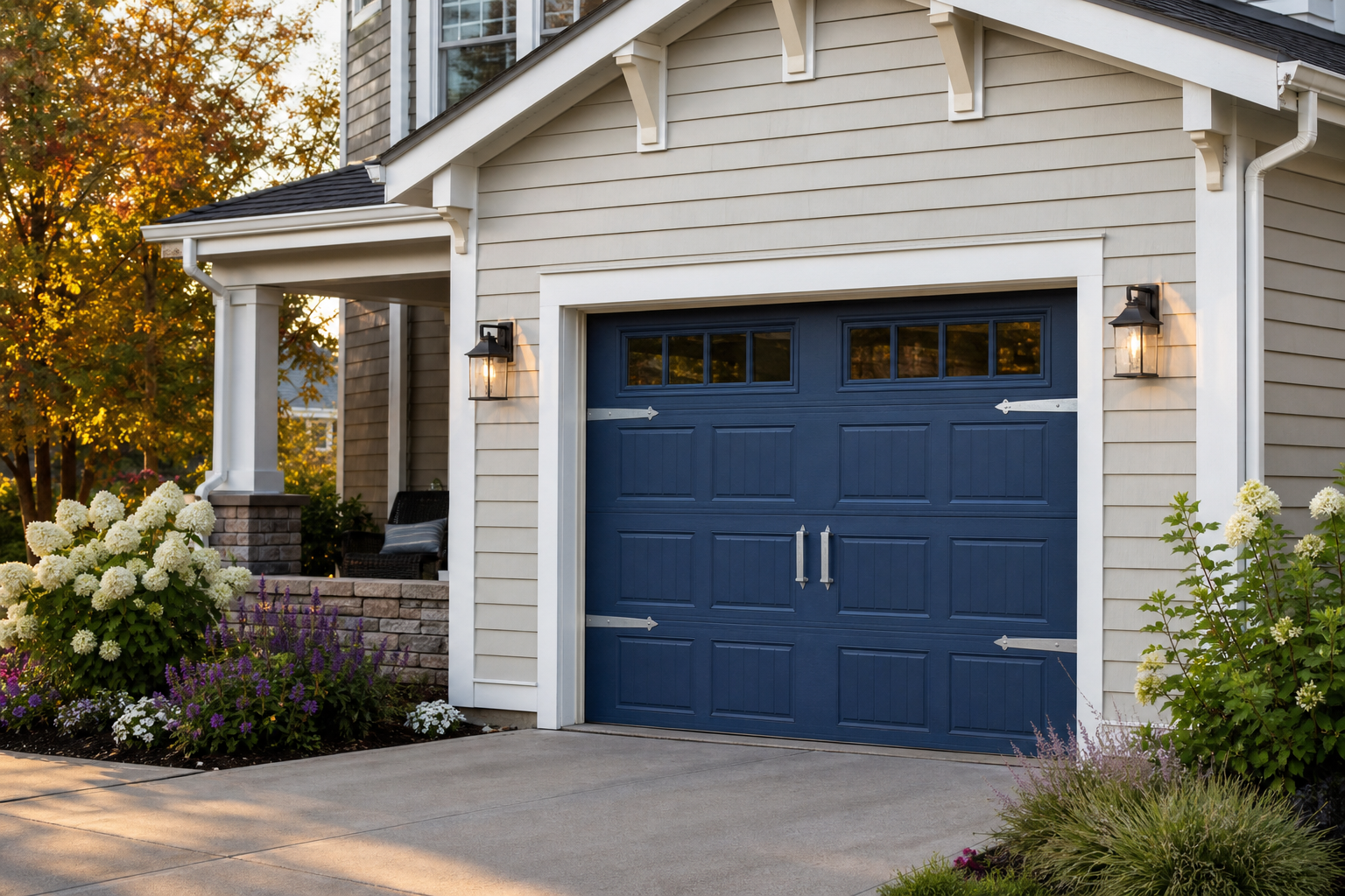 Single-car craftsman garage door painted navy blue with cream siding and brushed nickel hardware
