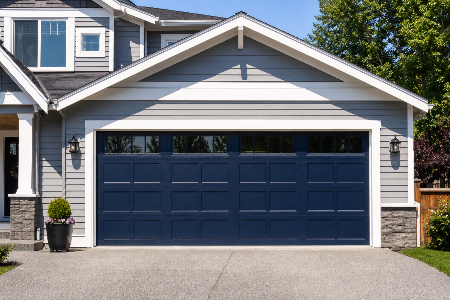 Light gray craftsman home with navy garage door framed by bold white contrasting trim border
