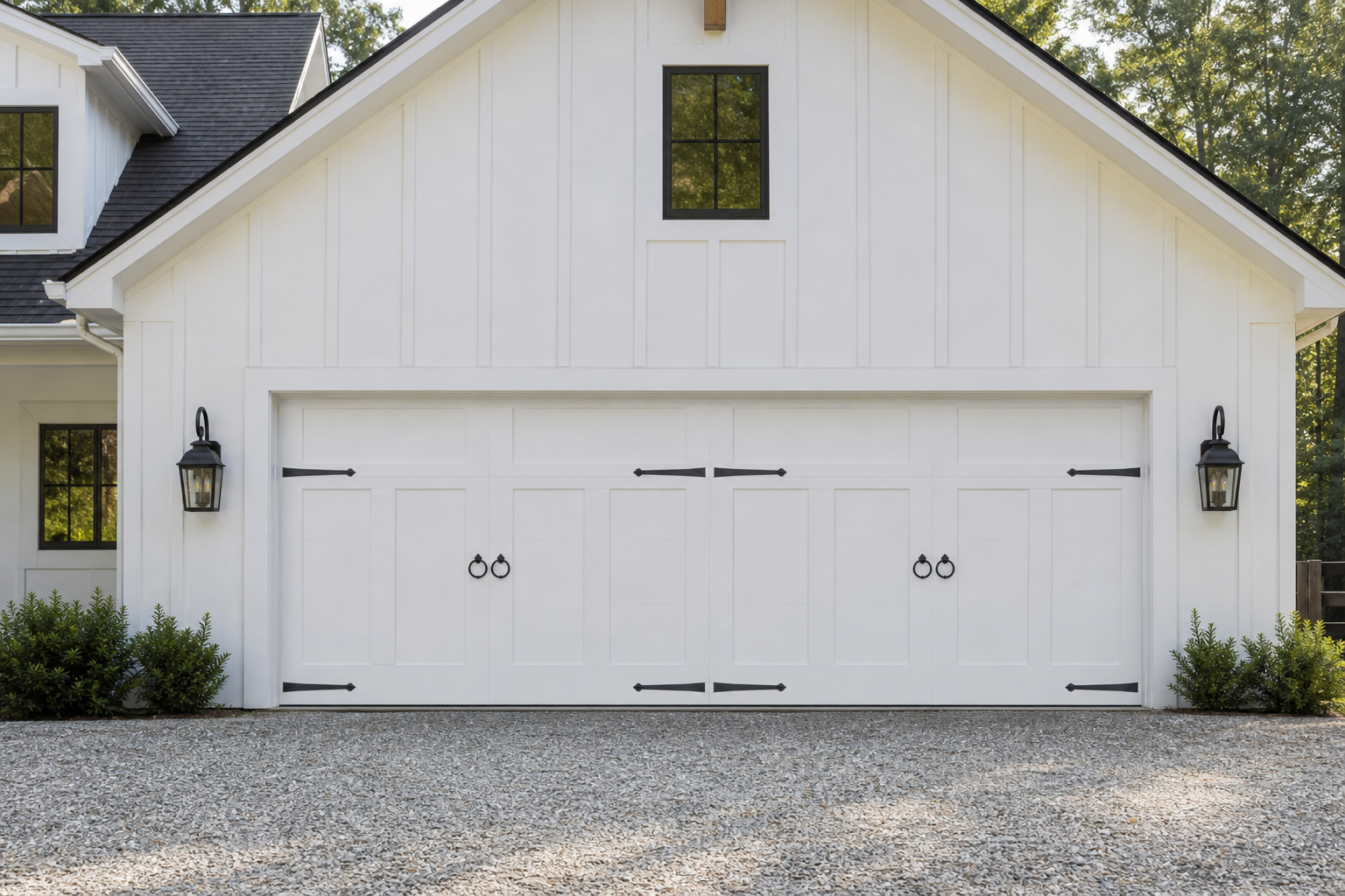 White farmhouse garage door with matte black decorative strap hinges and ring pull hardware accents