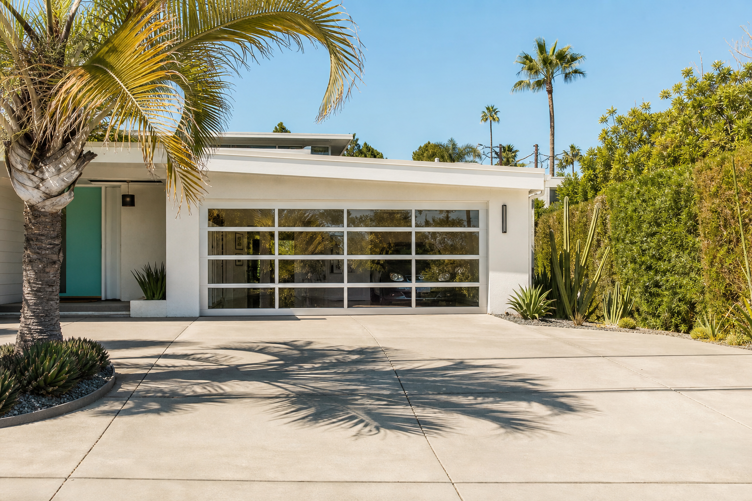 Mid-century modern home with wide two-car full-view white aluminum frame glass garage door
