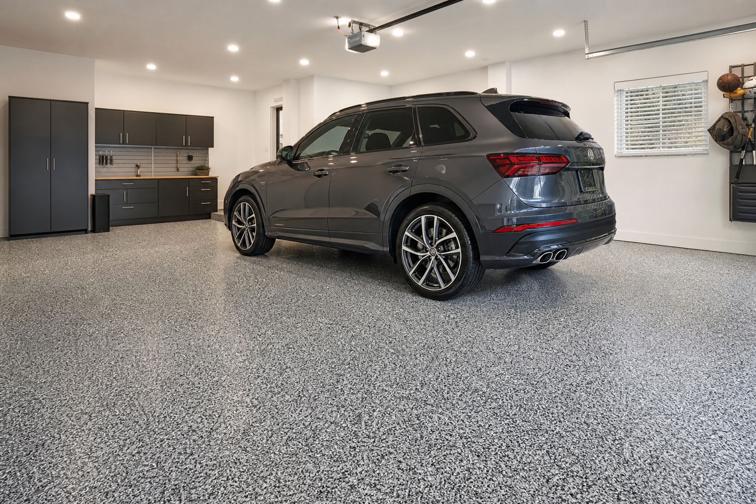 Garage floor with classic gray and white dense vinyl flake epoxy chip finish under LED lighting