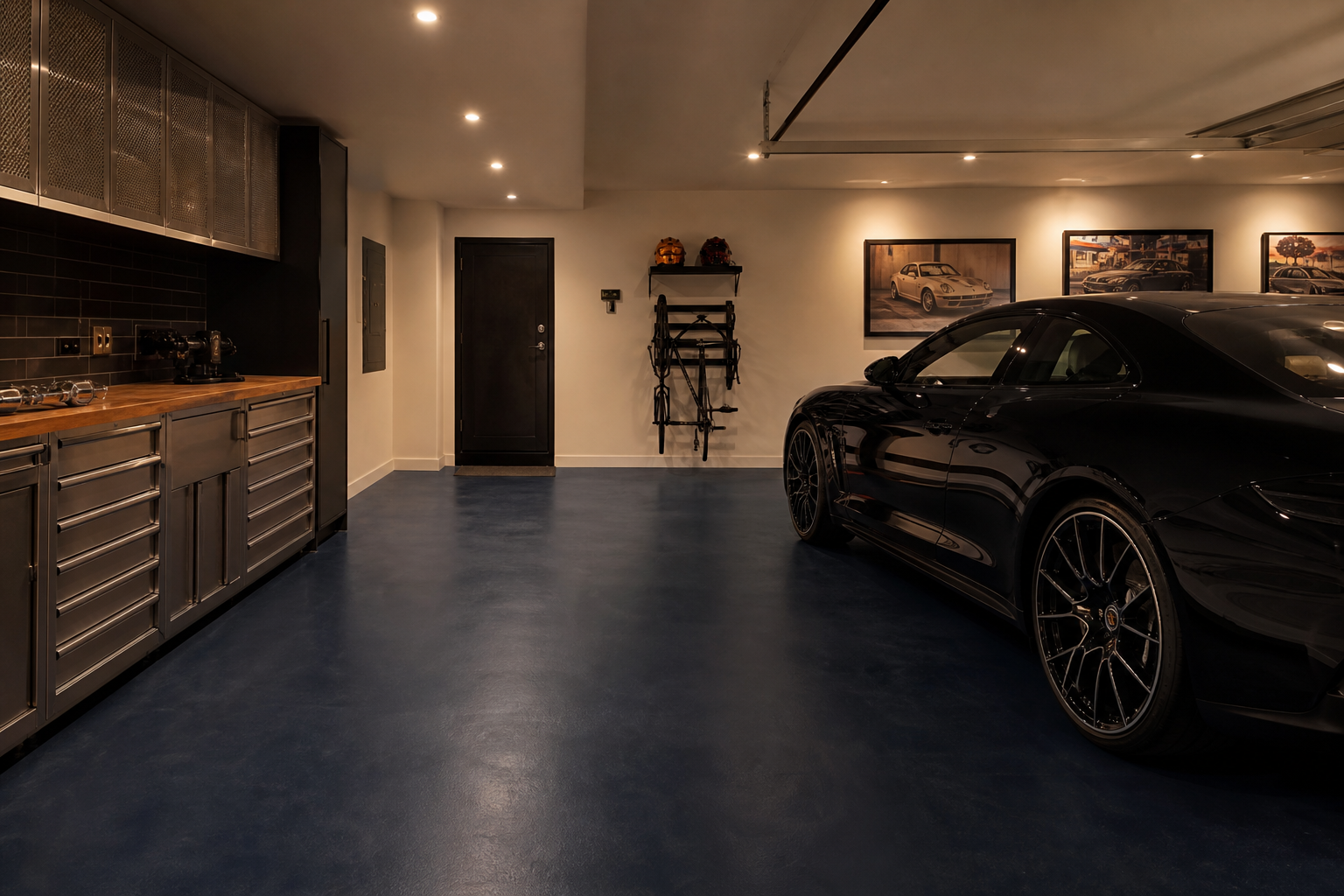 Deep navy blue matte painted concrete garage floor with stainless tool cabinet and black car