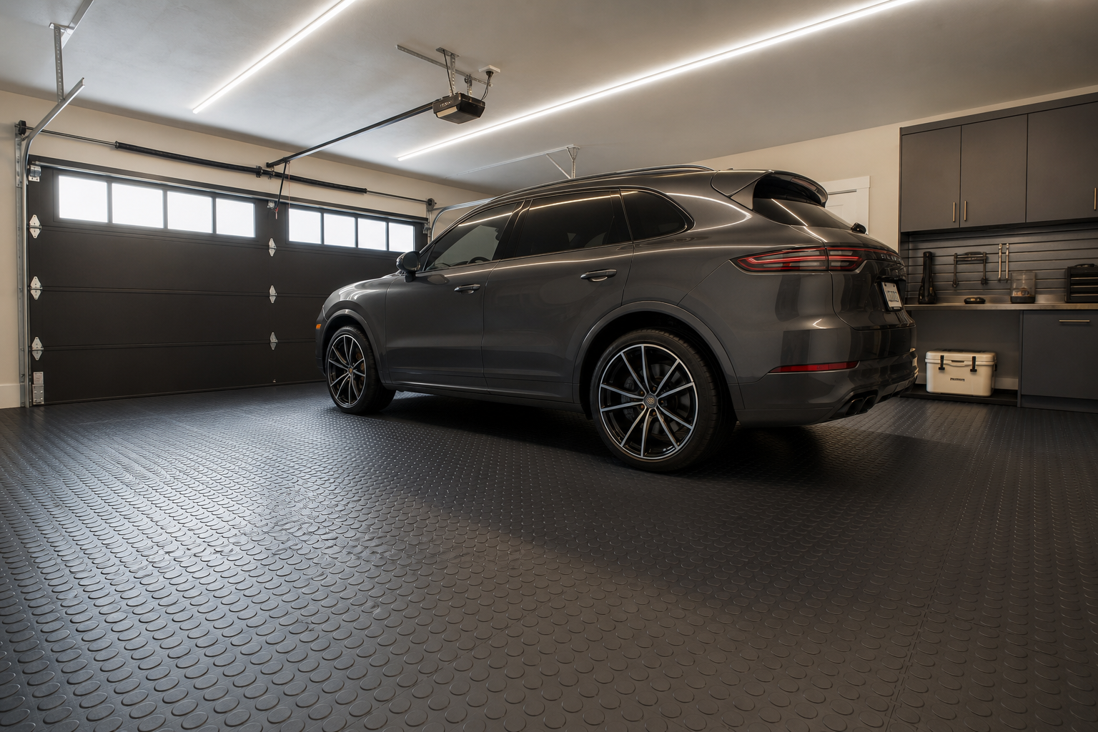 Dark charcoal coin-top rubber interlocking garage floor tiles in a modern two-car garage