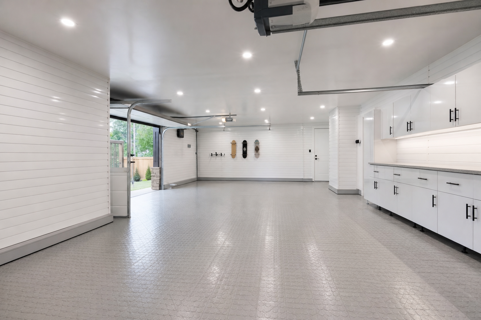 Bright white PVC wall panels and light gray coin-top interlocking floor tiles in a clean garage showroom setup