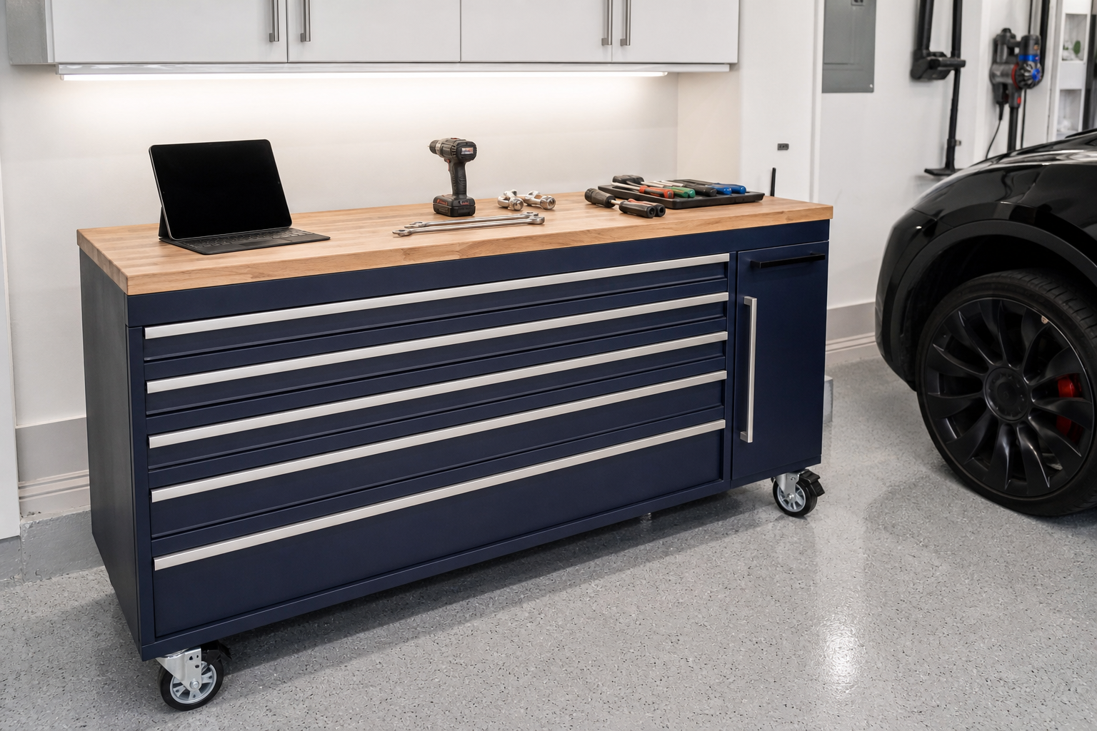 Navy blue rolling tool chest with butcher block wood top in a clean finished garage with white walls