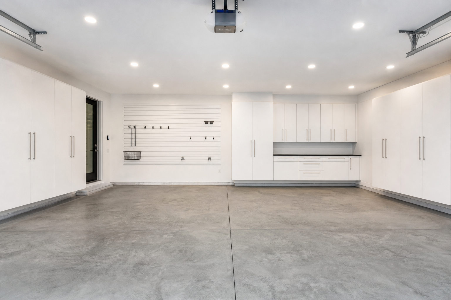 All-white garage walls and ceiling with white slatwall and built-in cabinets