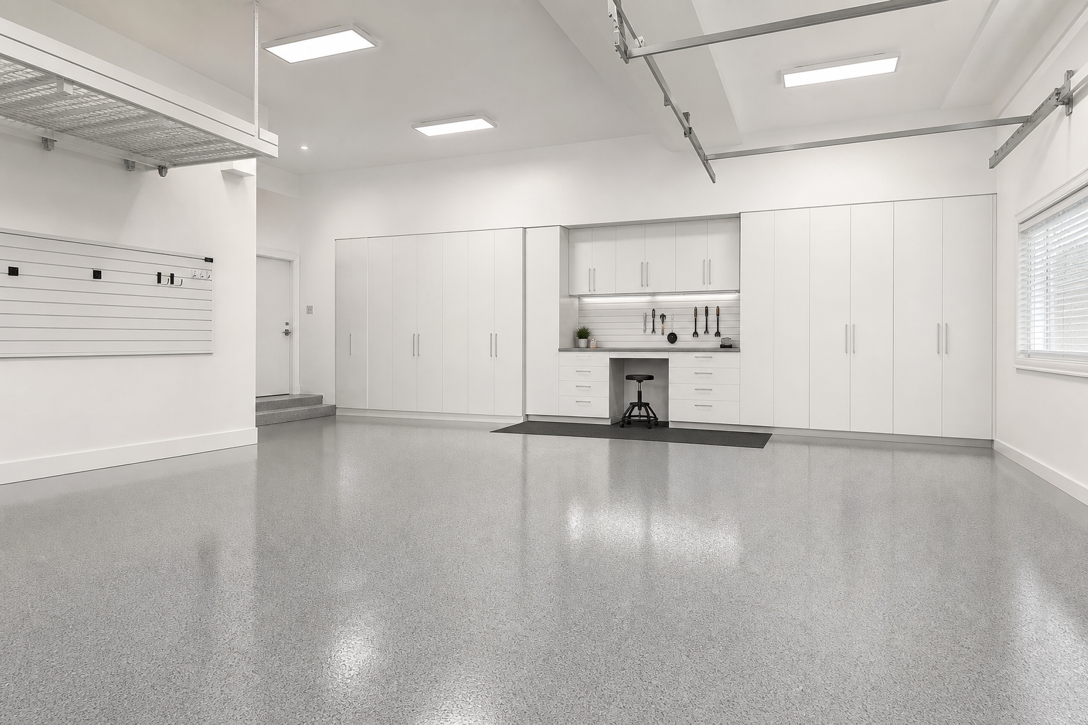 All-white garage with pale gray epoxy floor, white cabinets, and minimal black accents